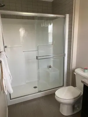a bathroom with a glass shower with a toilet at Mahogany's Comfy Haven in Calgary