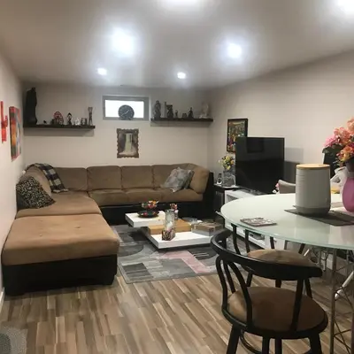 a living room with a couch and a table at Dolly's Deluxe Suite in Fort Saskatchewan