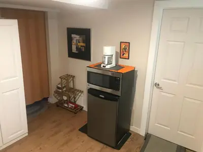 a kitchen with a microwave and a coffee maker on top of a refrigerator at Dolly's Deluxe Suite in Fort Saskatchewan