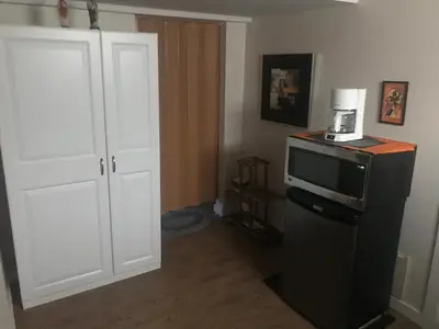 a kitchen with a microwave on top of a refrigerator at Dolly's Deluxe Suite in Fort Saskatchewan