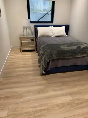 a bedroom with a bed and a wooden floor at Delux 2 bedroom suite in White Rock