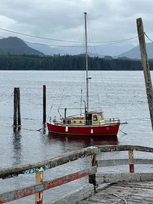 a boat sitting in the water next to a dock at Sweet Home Alert Bay in Alert Bay
