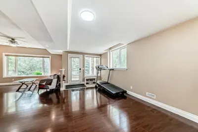 an empty living room with a hardwood floor and windows at cozy two bedrooms with external bathroom just for you in Calgary