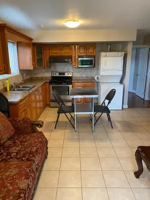 a kitchen with a table and chairs in a room at Large suite with separate access in Richmond