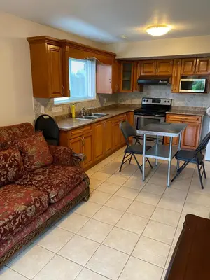 a living room with a couch and a table at Large suite with separate access in Richmond
