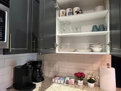 a kitchen with black cabinets and flowers on the counter at Cozy Canmore resort with mt view hot tub and pool in Canmore