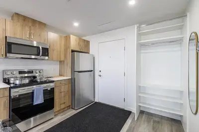 a kitchen with wooden cabinets and a stainless steel refrigerator at DT Edmonton King Suite with Parking & 100 Walk Score in Edmonton