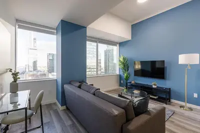 a living room with a couch and a blue wall at DT Edmonton King Suite with Parking & 100 Walk Score in Edmonton