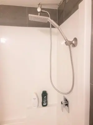 a shower with a shower head in a bathroom at Lovely Modern 2 Bedroom Basement Suite in Edmonton