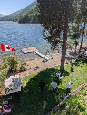 a group of people walking on the shore of a lake at Beachfront Lake House Moyie BC in Moyie