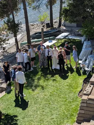 a group of people standing around in the grass at Beachfront Lake House Moyie BC in Moyie