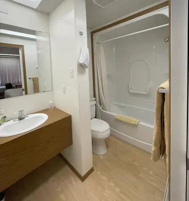 a bathroom with a sink and a toilet and a tub at Rest Easy Motel in Three Hills
