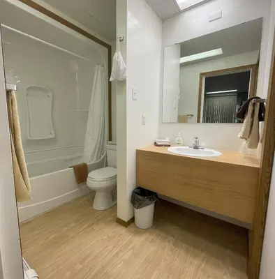 a bathroom with a sink and a toilet and a mirror at Rest Easy Motel in Three Hills