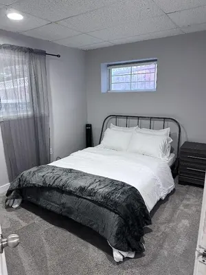 a bedroom with a large bed with white sheets at Valley Gateway in Calgary