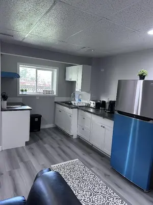 a kitchen with a blue refrigerator and white cabinets at Valley Gateway in Calgary