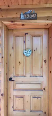 a wooden door with a welcome sign on it at Beautiful Cabin near Radium Hot Springs with private hot tub in Radium Hot Springs