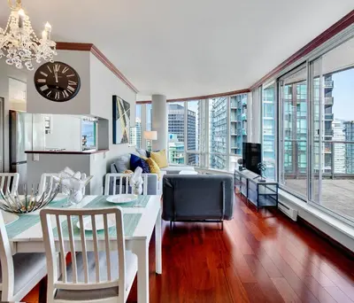 a kitchen and dining room with a clock on the wall at Luxury 2BR Designer Apartment In The Heart Of Downtown! in Vancouver