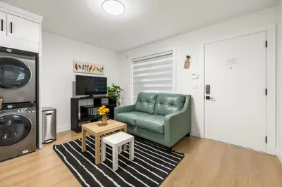 a living room with a green chair and a table at A cozy and stylish 2-bedroom retreat in Surrey