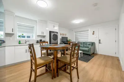 a kitchen and dining room with a table and chairs at A cozy and stylish 2-bedroom retreat in Surrey