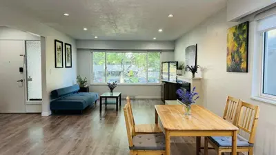 a living room with a table and a blue couch at Cozoro 3 BEDROOMS Centre Vancouver in Vancouver
