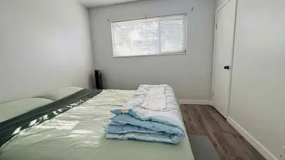 a bedroom with a bed with blue sheets and a window at Cozoro 3 BEDROOMS Centre Vancouver in Vancouver