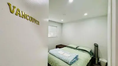 a bedroom with a bed with a sign on the wall at Cozoro 3 BEDROOMS Centre Vancouver in Vancouver