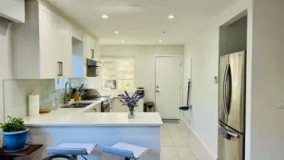 a kitchen with white cabinets and a refrigerator at Cozoro 3 BEDROOMS Centre Vancouver in Vancouver