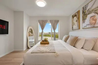 a bedroom with a large white bed with a window at 3 Bedroom Luxurious Seton Town Home with Central AC and Lake View in Calgary
