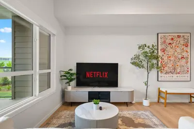 a living room with a tv on a white wall at 3 Bedroom Luxurious Seton Town Home with Central AC and Lake View in Calgary