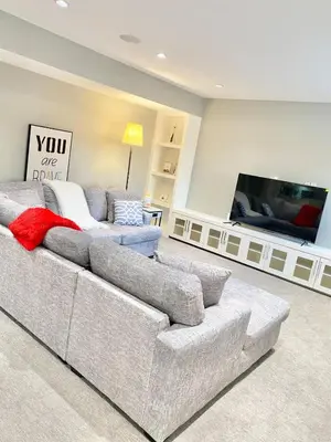 a living room with a couch and a flat screen tv at Luxury Chestermere Retreat in Calgary