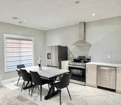 a kitchen with a table and chairs in it at Luxury Chestermere Retreat in Calgary