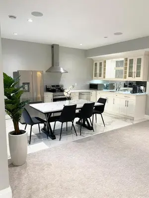 a white kitchen with a table and chairs in it at Luxury Chestermere Retreat in Calgary