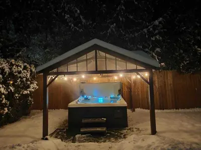 a gazebo with lights in the snow at night at The HI-Mark House - Hot tub,AC,Pool table, Pool May2026 in Sicamous