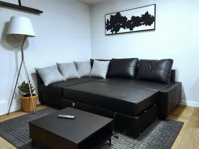 a black leather couch in a living room with a table at Cozy 2 BR Suite Self check-in I Free Park Pass in Calgary