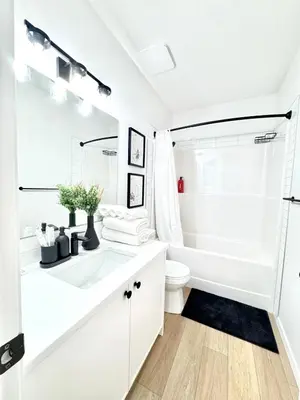 a white bathroom with a tub and a toilet at Cozy 2 BR Suite Self check-in I Free Park Pass in Calgary