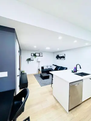 a kitchen and living room with a counter and a kitchen island at Cozy 2 BR Suite Self check-in I Free Park Pass in Calgary