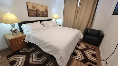 a bedroom with a bed and a night stand with a lamp at 3 Bedroom House Near Airport and Downtown in Calgary