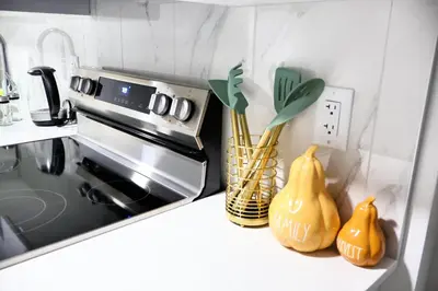 a kitchen with a stove with two yellow vases at Apartment In Calgary Near Airport in Calgary