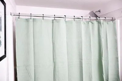 a shower curtain hanging from a rod in a bathroom at Apartment In Calgary Near Airport in Calgary
