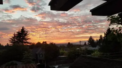 a view of a sunset from the balcony of a house at Shaughnessy Heritage Manor on Vancouver's Westside free housekeeping optional in Vancouver