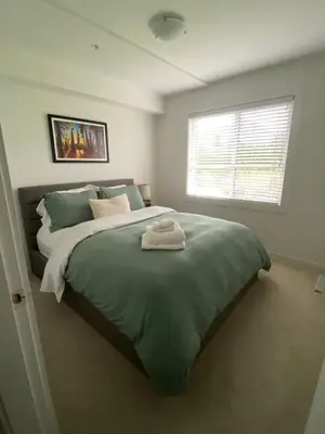 a bedroom with a large green bed with a window at Stylish Three Bedroom Townhome in Squamish