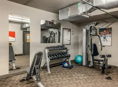 a gym with treadmills and weights in a room at Best 2BR Canmore Stay, Banff, Wifi & Free Parking Incl in Dead Man's Flats