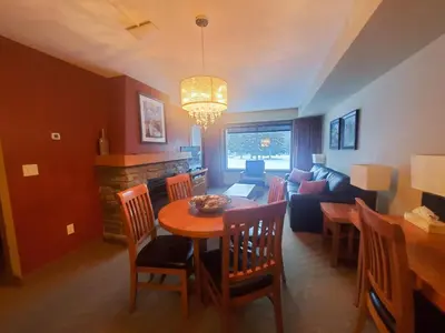 a living room with a table and a couch at Best 2BR Canmore Stay, Banff, Wifi & Free Parking Incl in Dead Man's Flats