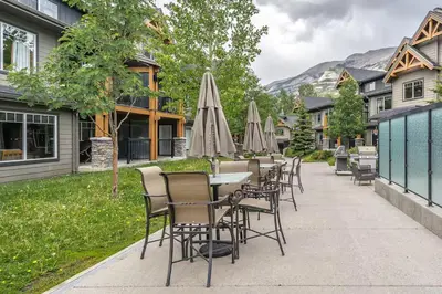 a row of tables and chairs with umbrellas at Best 2BR Canmore Stay, Banff, Wifi & Free Parking Incl in Dead Man's Flats