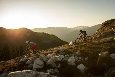 two people riding bikes on top of a mountain at 1BR and Sofabed in Marquise, Near Ski Hill, Fireplace, Hot Tub and Sauna, Gym Access in Whistler