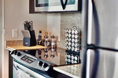 a kitchen with a counter with a stove and a refrigerator at Urbanest - Spectacular Views & Amenities Parking in Calgary