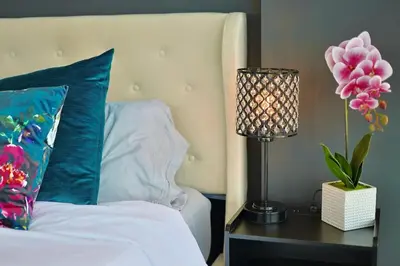 a bed with a blue pillow and a table with a lamp at Urbanest - Spectacular Views & Amenities Parking in Calgary