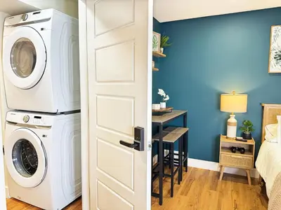 a room with a washer and dryer next to a bedroom at Private Studio - 5 Min to DT - Self Check-In - 75 Inch TV in Williams Lake