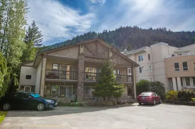 a house with two cars parked in a parking lot at The Driftwalk Walkable to Beach in Harrison Hot Springs