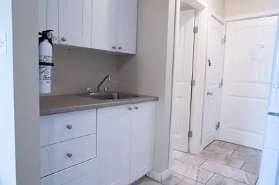 a kitchen with white cabinets and a sink at RiversTail Retreat Pet-Friendly and Steps to The Lake in Harrison Hot Springs